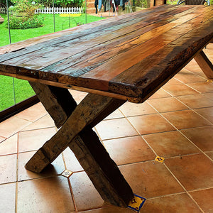 Canai, compañero en Mapudungun. Una mesa rústica creada por Artesanos Chilenos. Roble reciclado y barnices 100% naturales. Espesor de cubierta de 6 cm con regrueso. Patas en X de 4 x 6 pulgadas. 