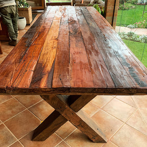 Canai, compañero en Mapudungun. Una mesa rústica creada por Artesanos Chilenos. Roble reciclado y barnices 100% naturales. Espesor de cubierta de 6 cm con regrueso. Patas en X de 4 x 6 pulgadas. 