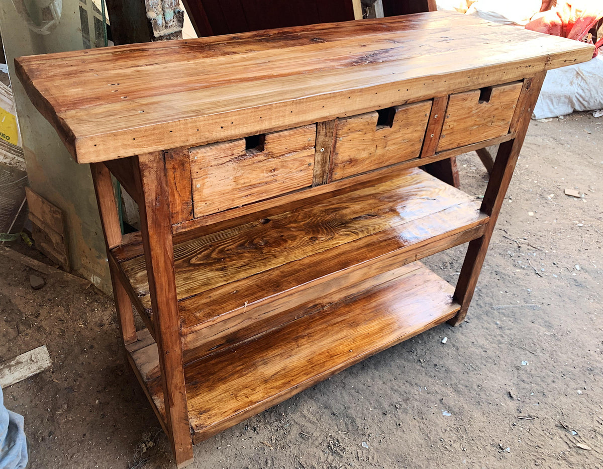 Arrimo de madera reutilizada con cajones y repisas, diseño robusto ideal para entrada de hogar.