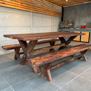 Una mesa rústica con detalles que definen su historia y tradición Artesanal Chilena. Considera dos bancas laterales.