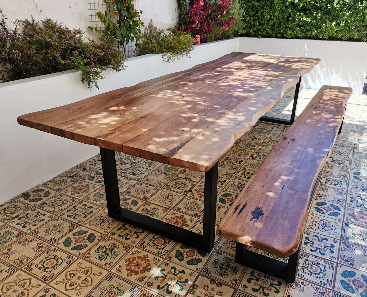 Mesa fabricada en Roble de Demolición y canto rústico. Un producto creado bajo un Modelo Sostenible. Considera 2 bancas laterales.