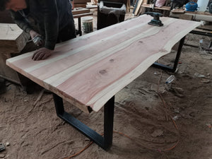 Mesa fabricada en Sequoia llena de vida con patas de fierro que contrastan con las vetas naturales de la madera.