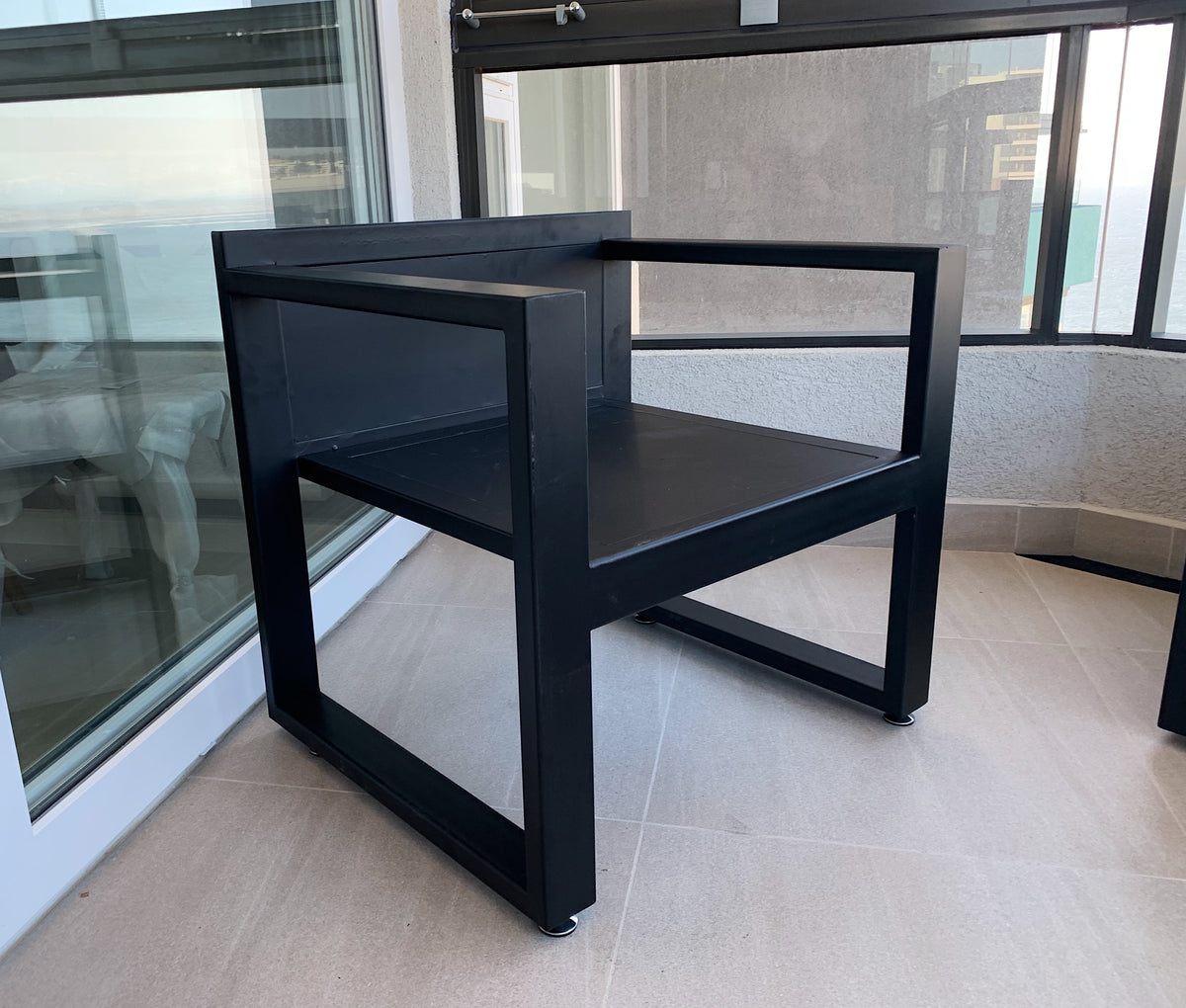 Terraza de perfiles de fierro de 80:40mm pensada para disfrutar del paisaje y con una mesa de centro en Roble de Demolición. Creada por Artesanos Chilenos que les sobra talento.