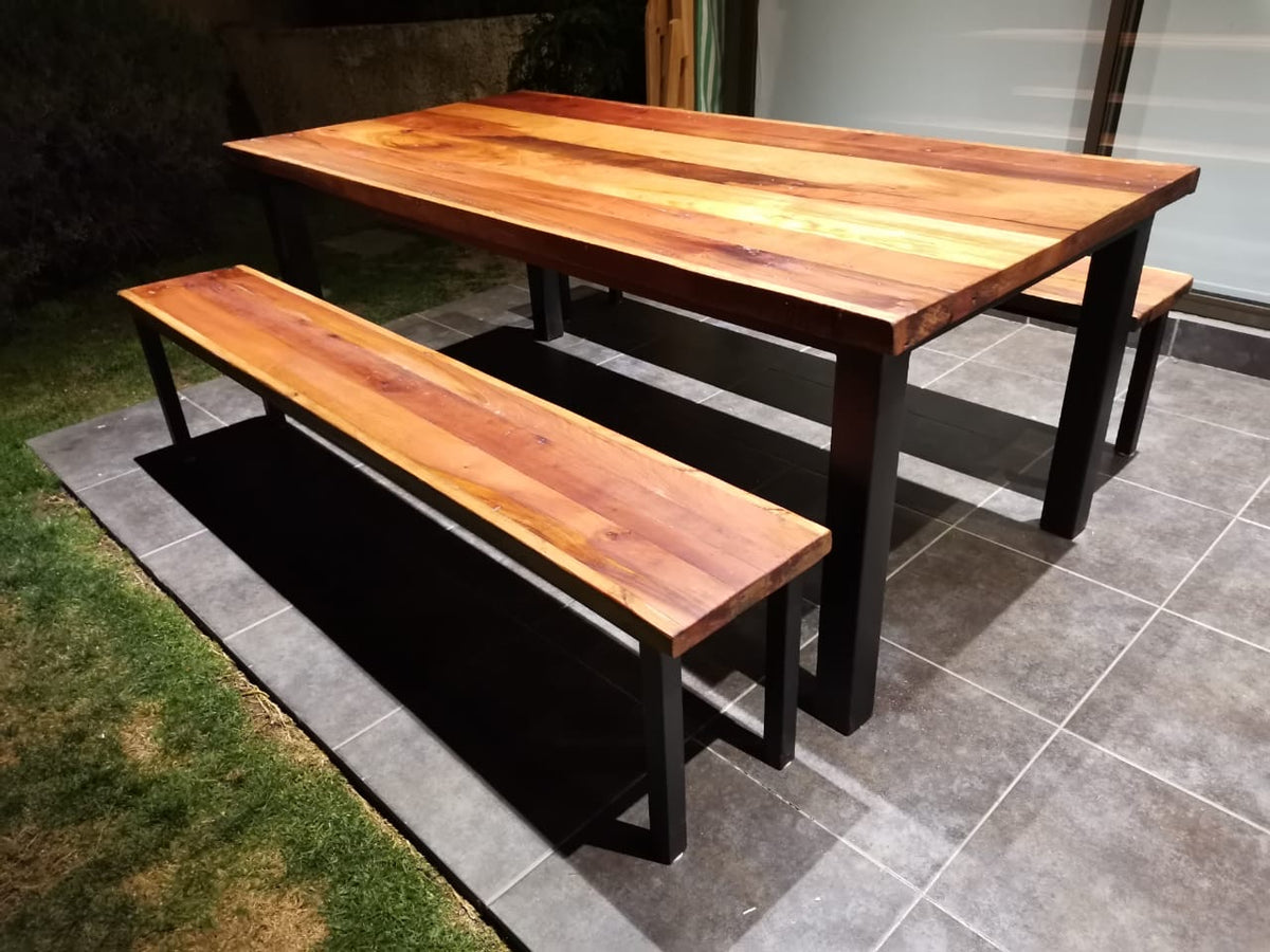 mesa comedor clásica pero con mezcla entre perfiles de fierro y cubierta de Roble de Demolición. Considera bancas.