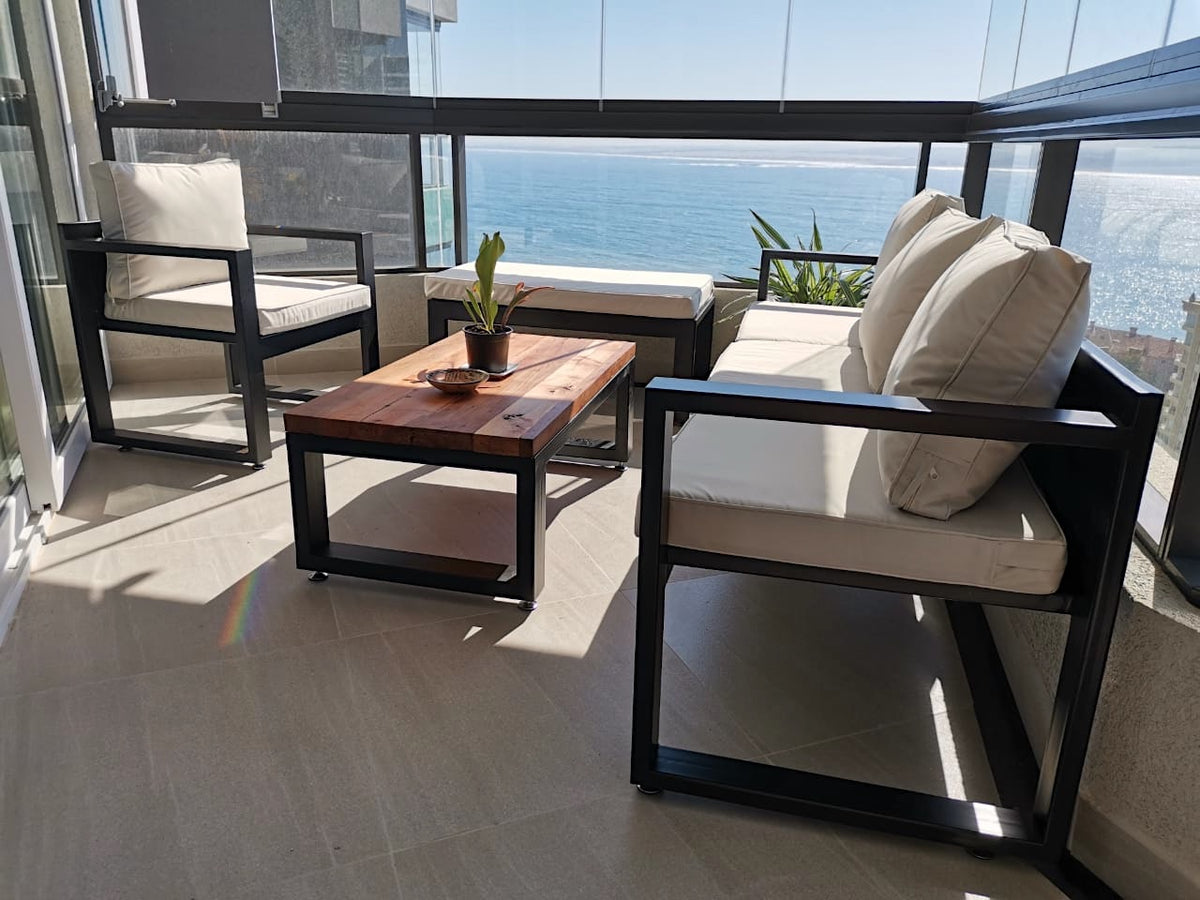 Terraza de perfiles de fierro de 80:40mm pensada para disfrutar del paisaje y con una mesa de centro en Roble de Demolición. Creada por Artesanos Chilenos que les sobra talento.